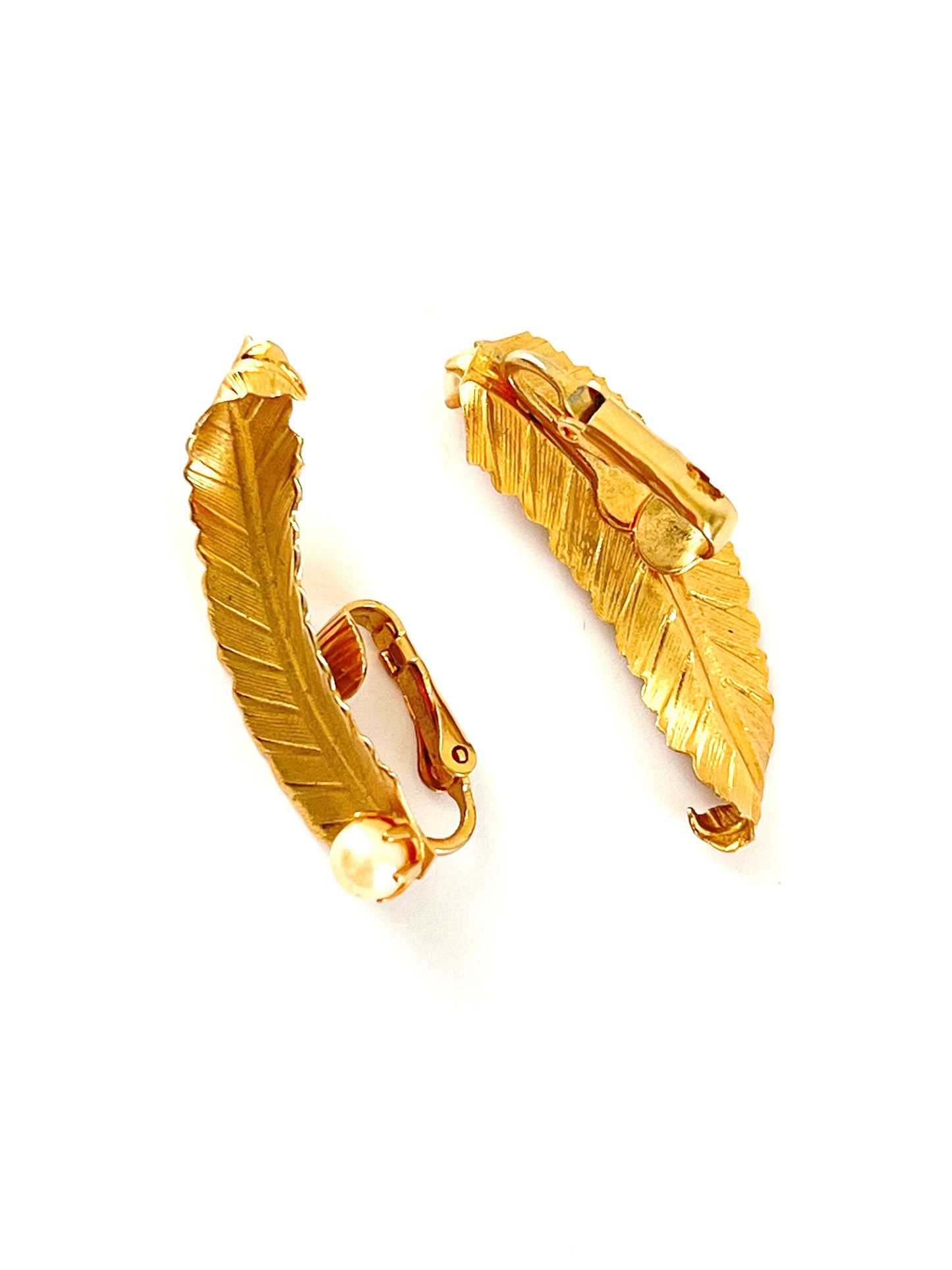 Pair of gold leaf-shaped earrings on a white background