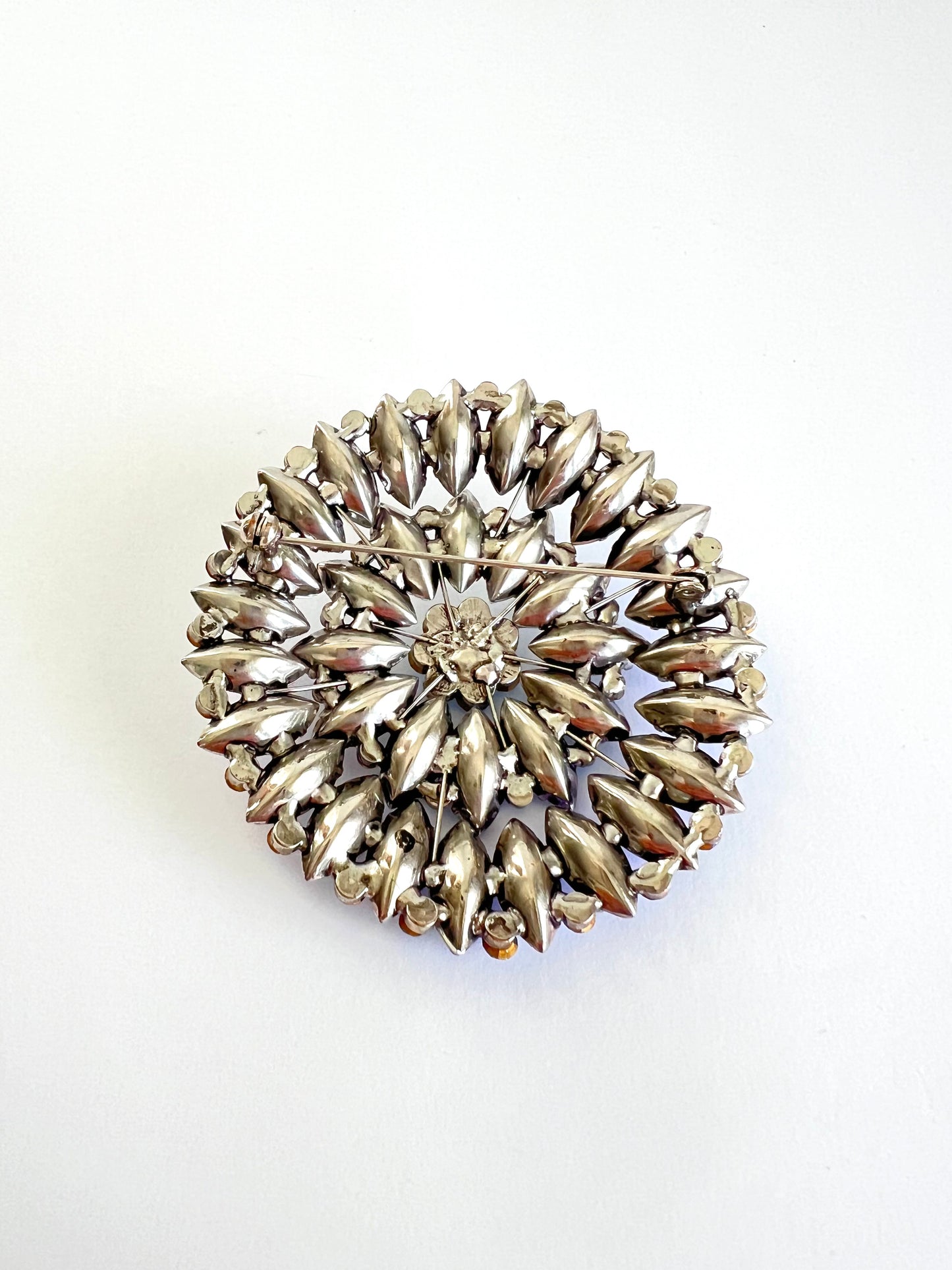 Large Mid Century Colorful Crystal Rhinestone Sunburst Brooch shown from the back.