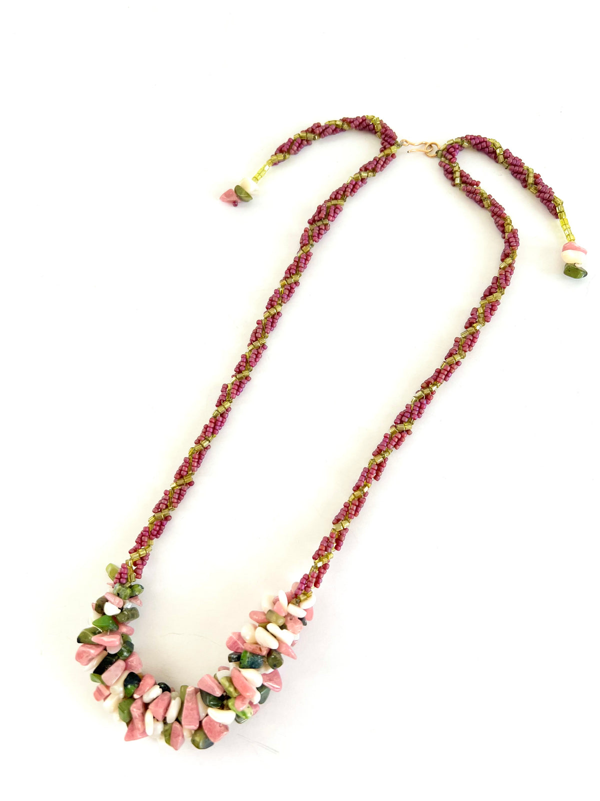 A handmade beaded necklace featuring a braided magenta and lime green cord with a chunky collar of irregular pink and green beads, displayed on a clean white background.